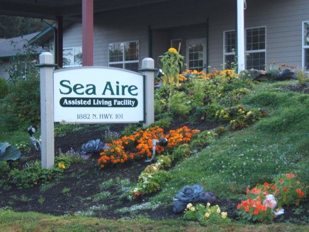 Exterior sign of Sea Aire Assisted Living Facility with flowers