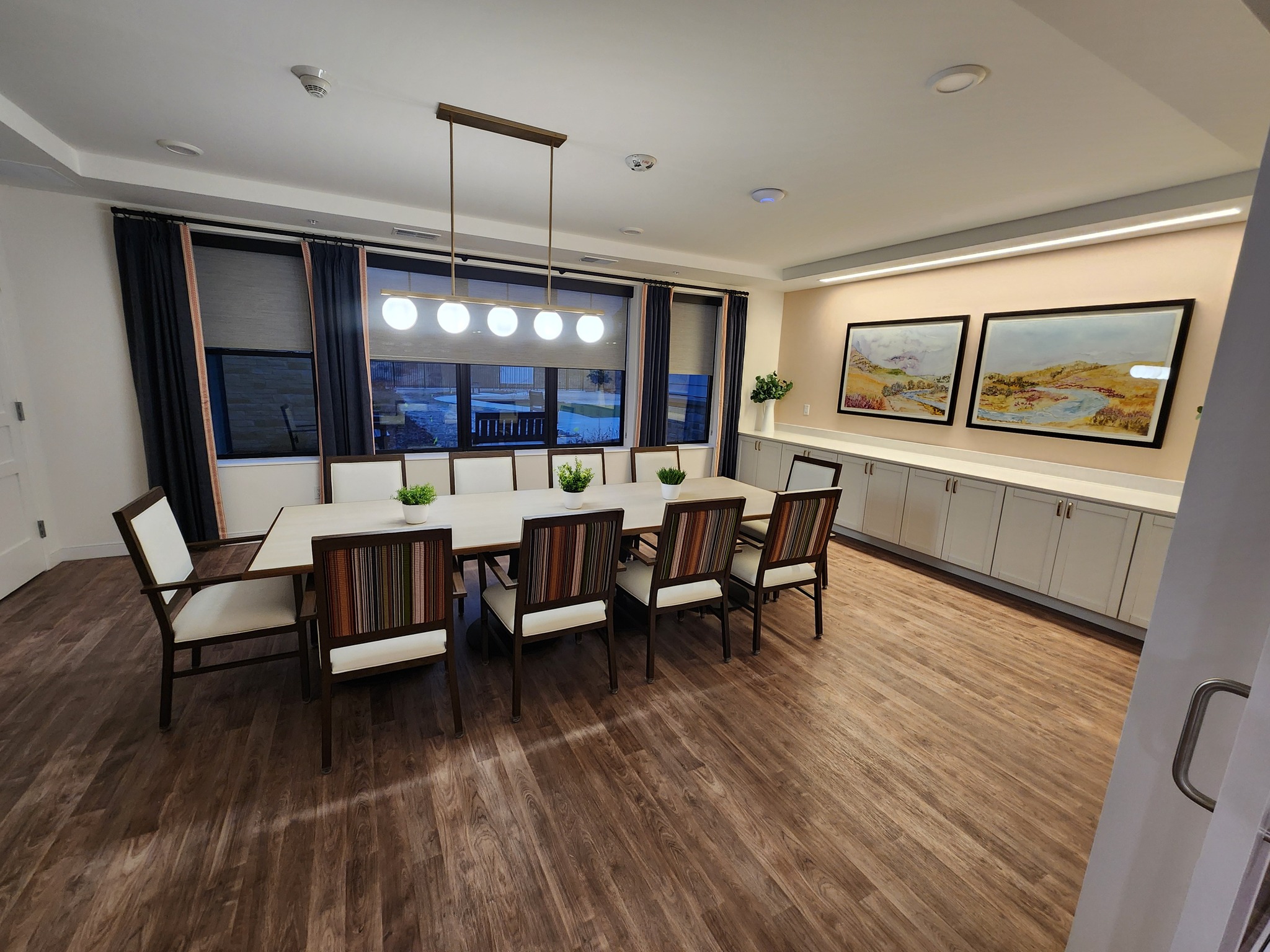 Bright common area with large dining table and chairs