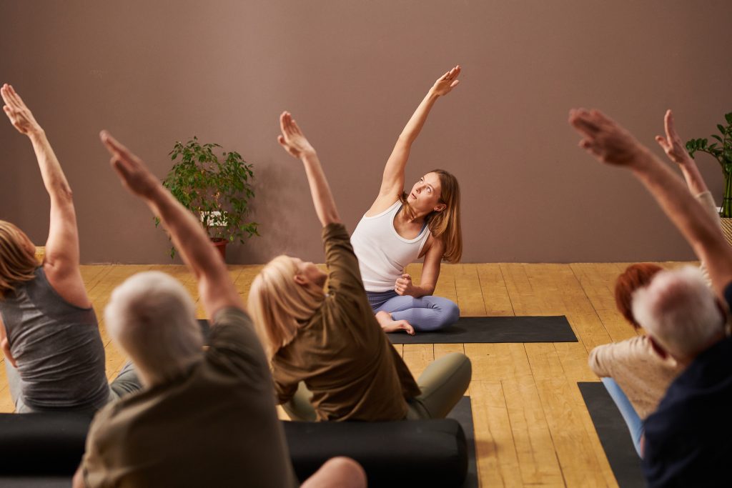 Residents participating in a yoga class in a bright indoor space