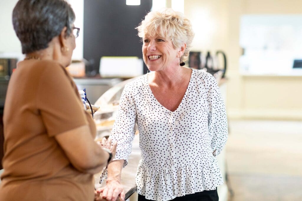 Two residents engaging in a conversation in a common area