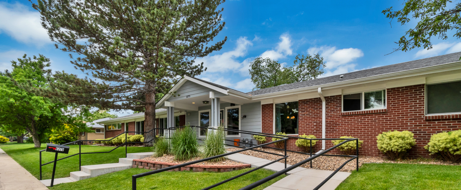 Front entrance of a senior living facility with landscaped pathways