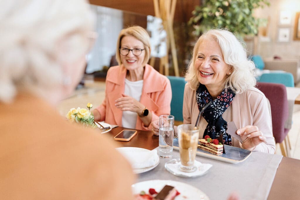 Residents enjoying cake and conversation in a common area