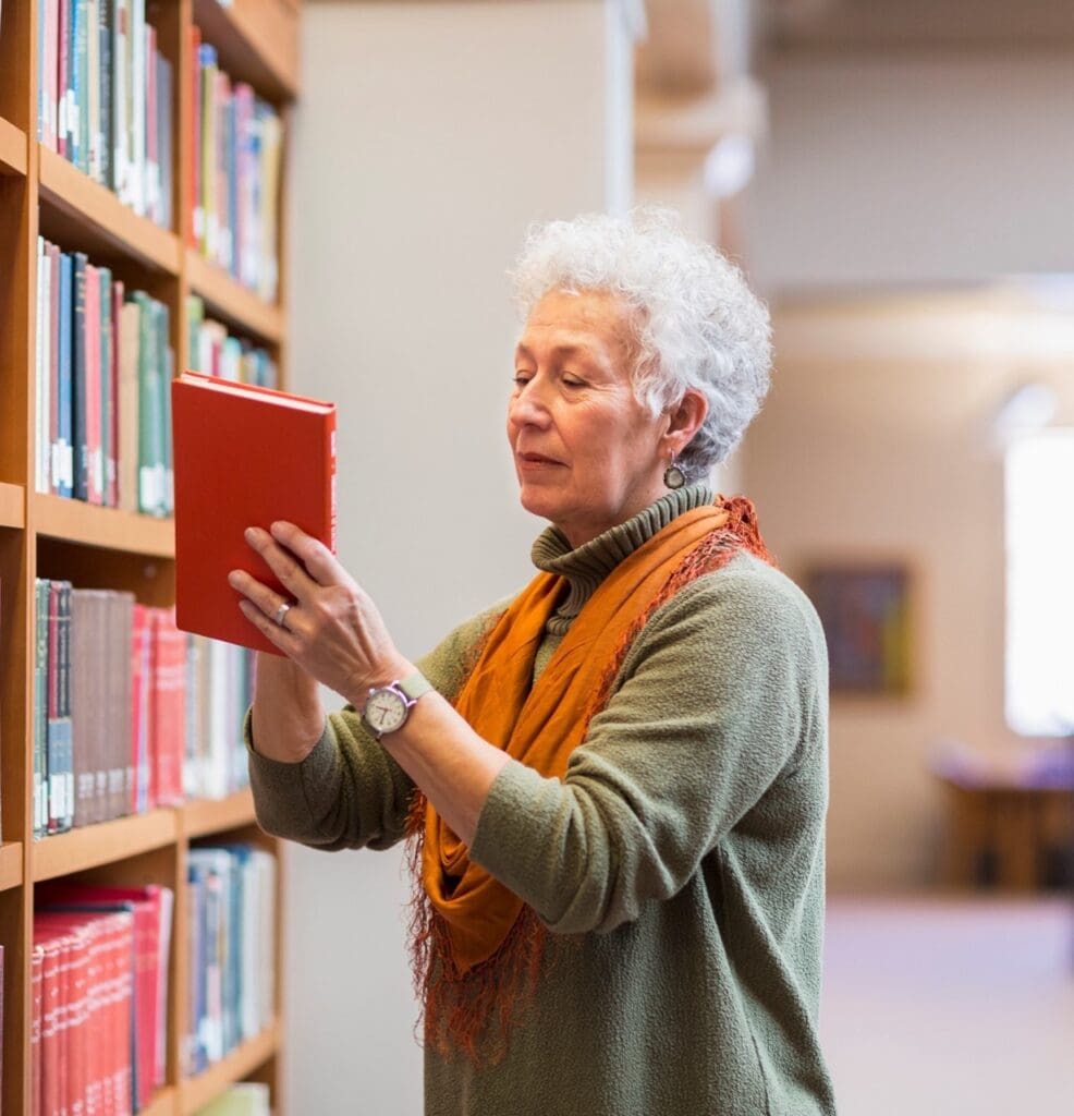 A resident selecting a book from a library shelf