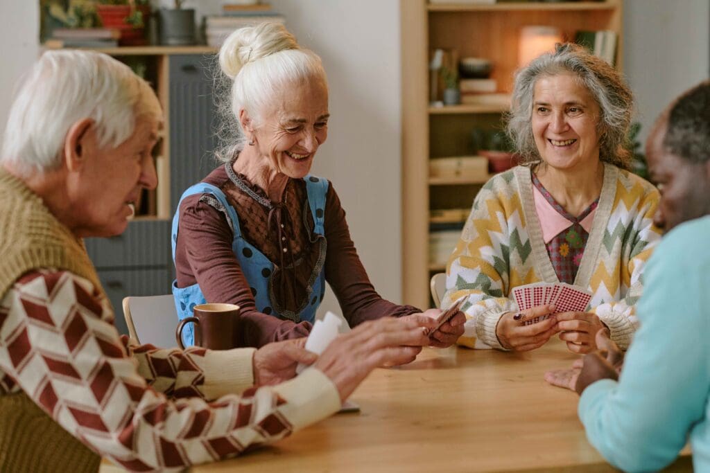 Seniors playing cards in a cozy common area