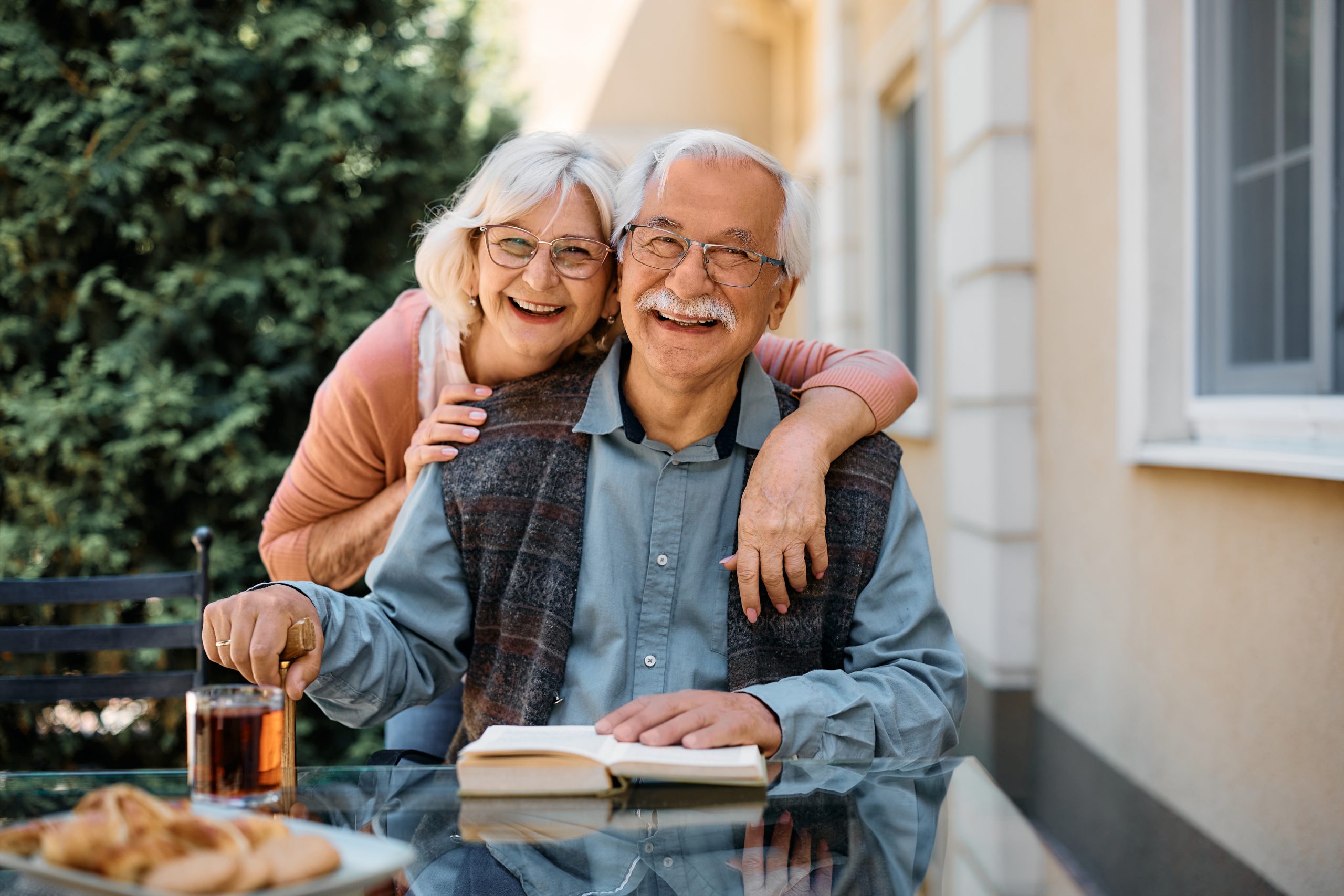 A happy elderly couple sitting outdoors together
