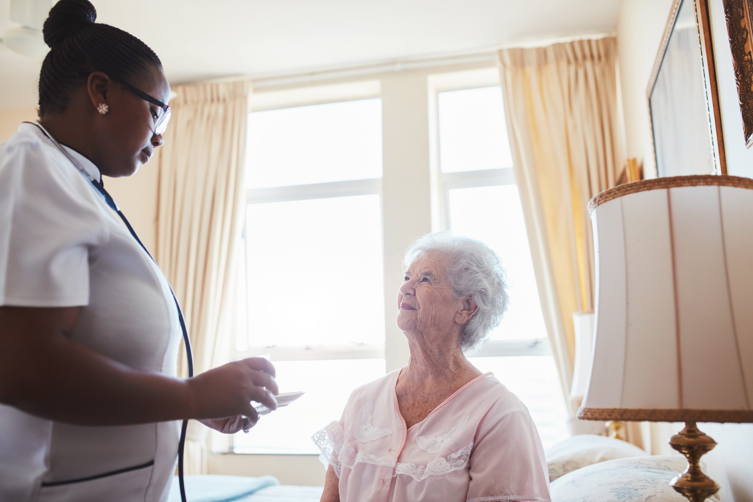 A caregiver interacting with a resident in a bright room