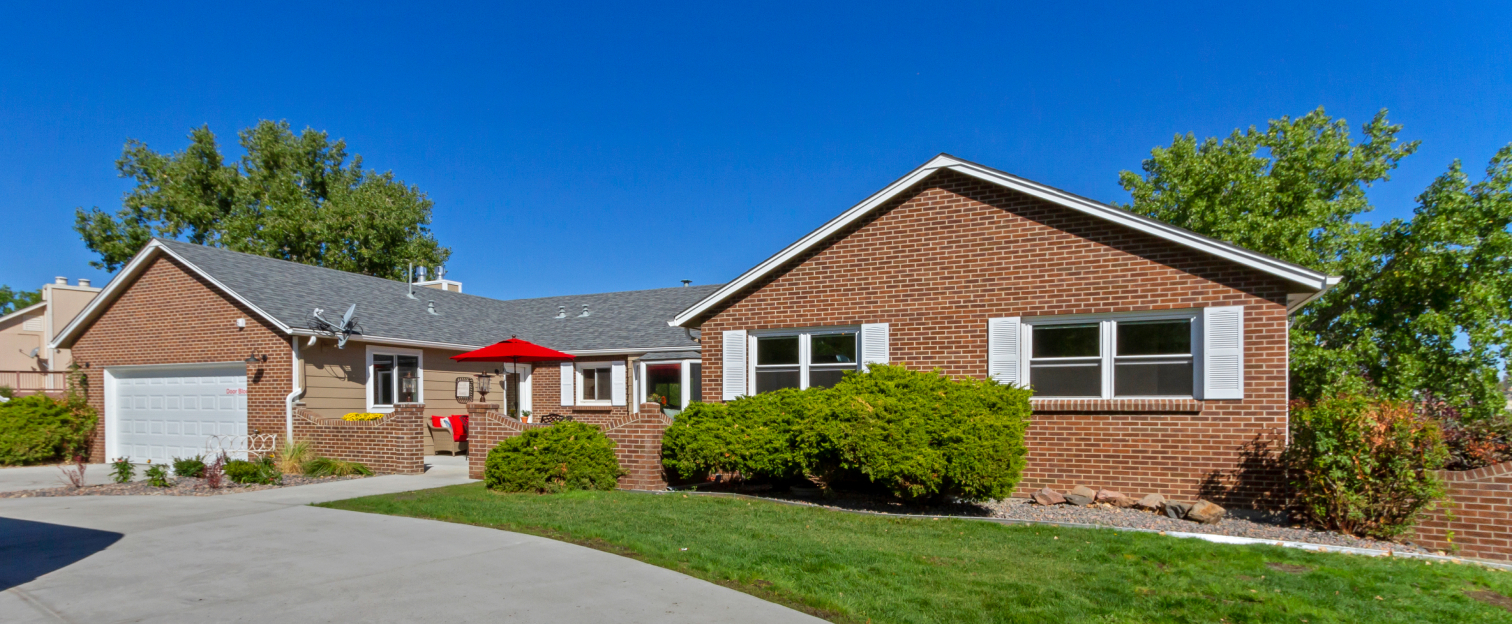 Front exterior of a senior living facility with gardens