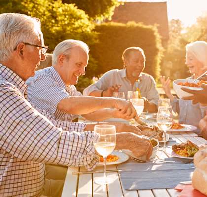Seniors enjoying a meal together outdoors