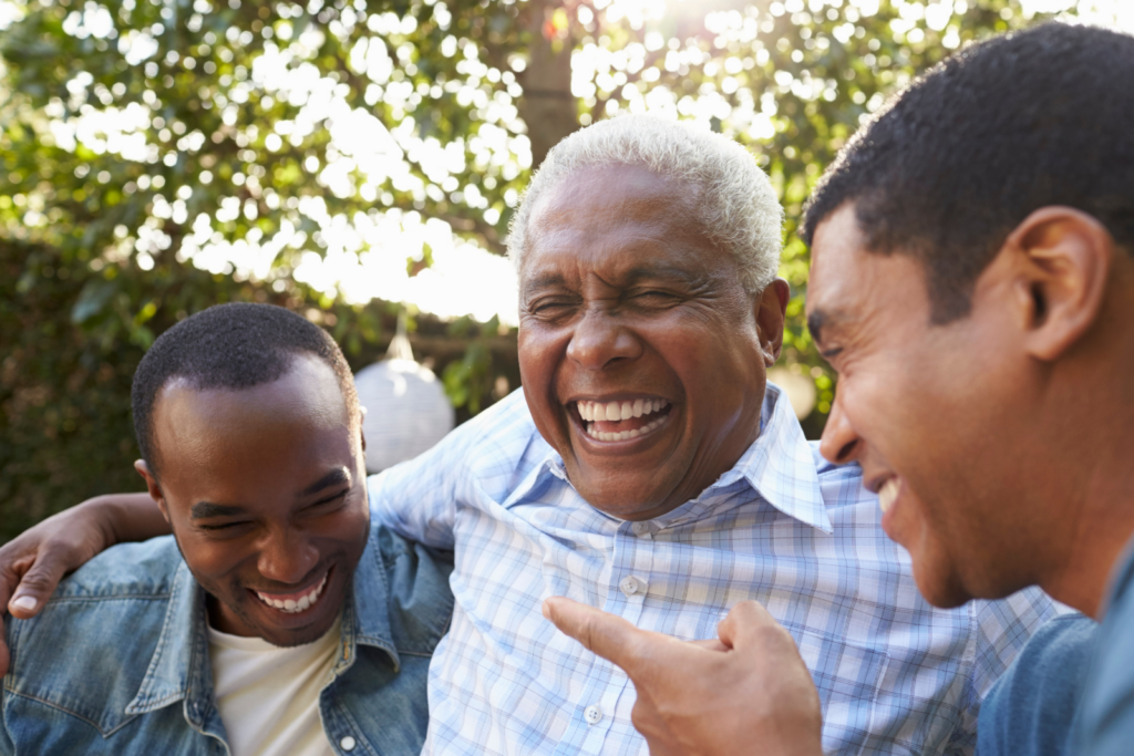 Three men laughing together outdoors