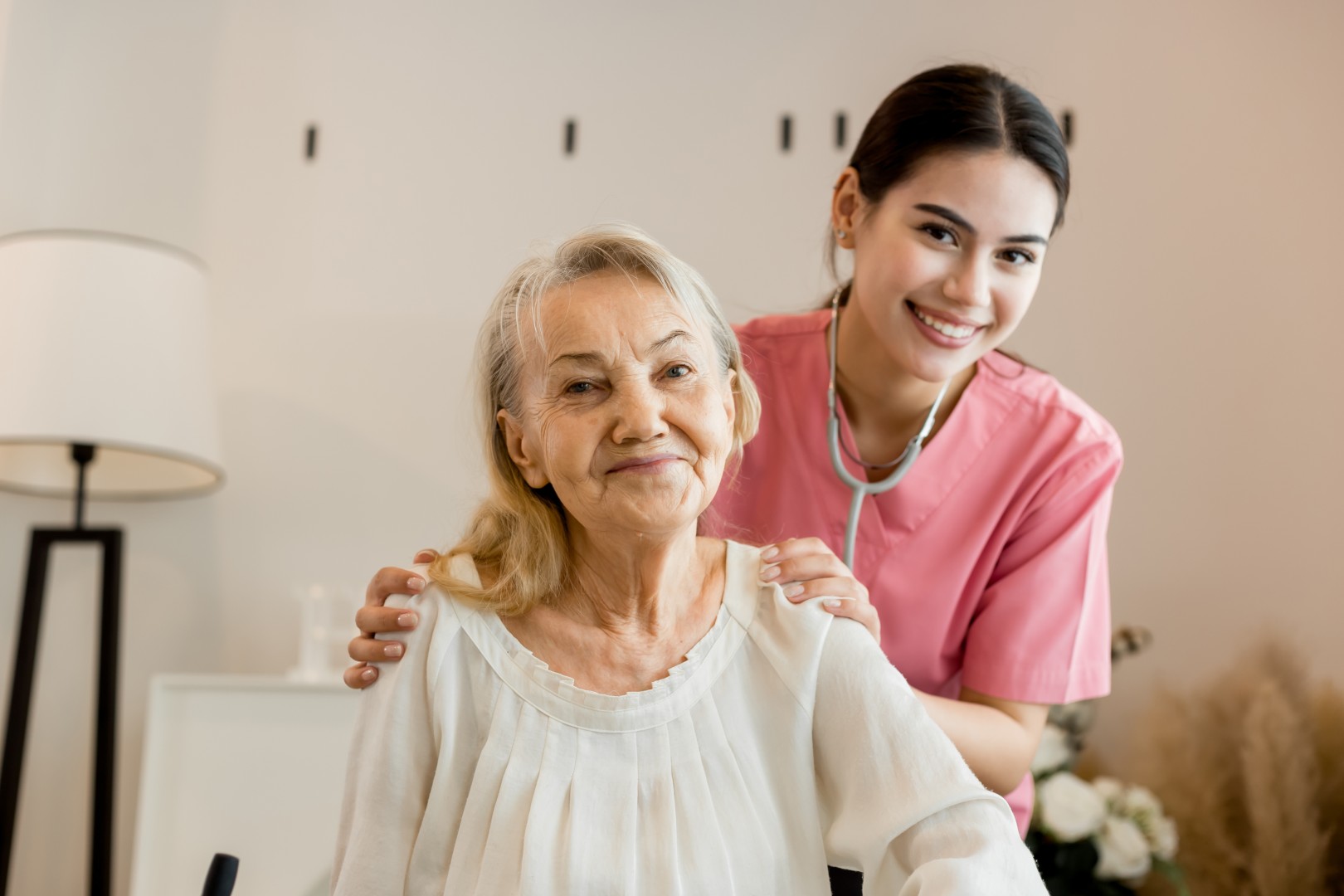 Caregiver assisting a smiling resident in a cozy setting