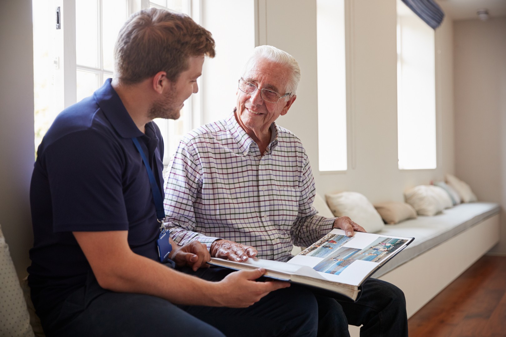 Staff member engaging with a resident over a photo album