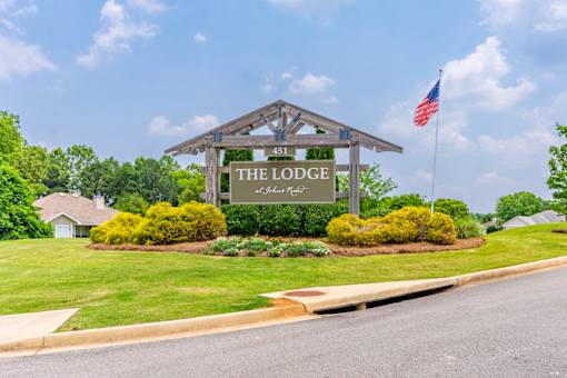 Exterior view of The Lodge at Johns Rd sign and landscaping