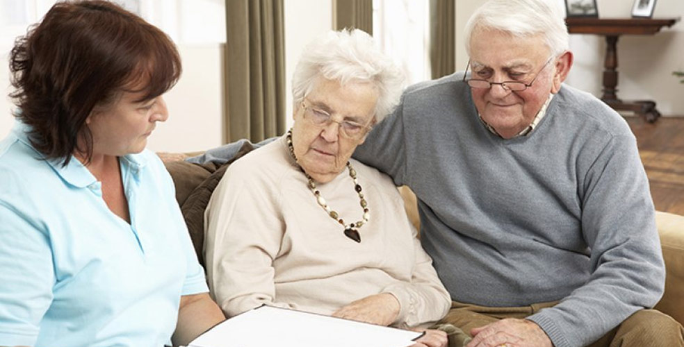 Caregiver engaging with elderly residents in a living room