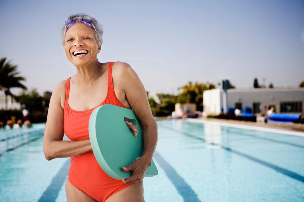 An older woman smiling by the pool during exercise