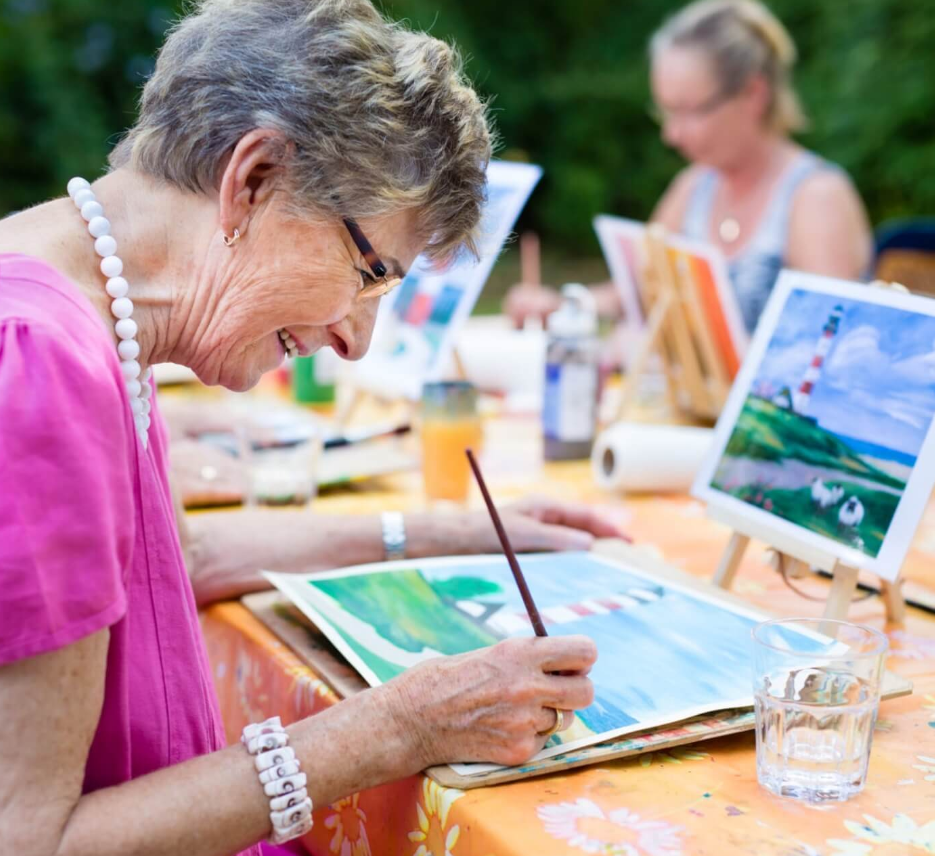Resident painting at an outdoor art activity