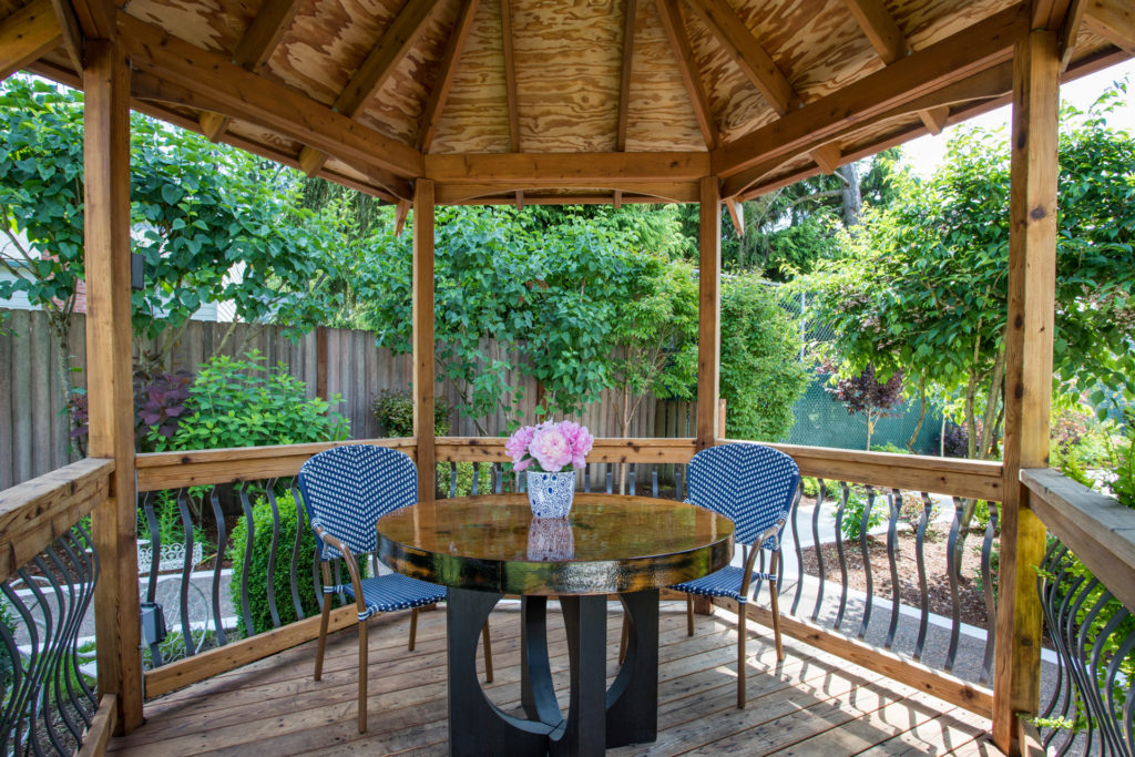 Outdoor gazebo with chairs and a vase of flowers