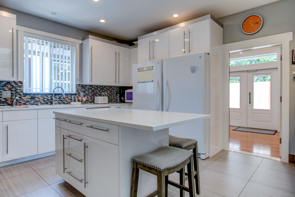 Modern kitchen area with an island and bar stools.
