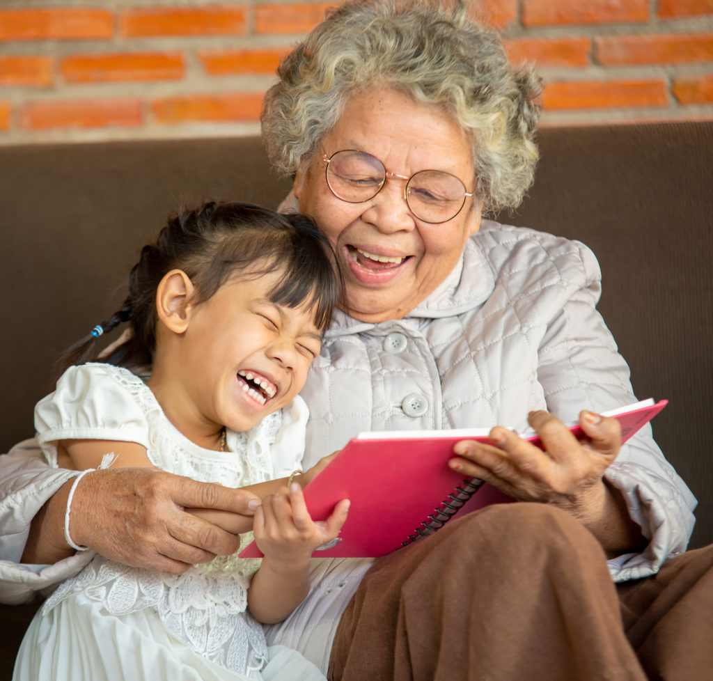Senior woman reading with a young girl.
