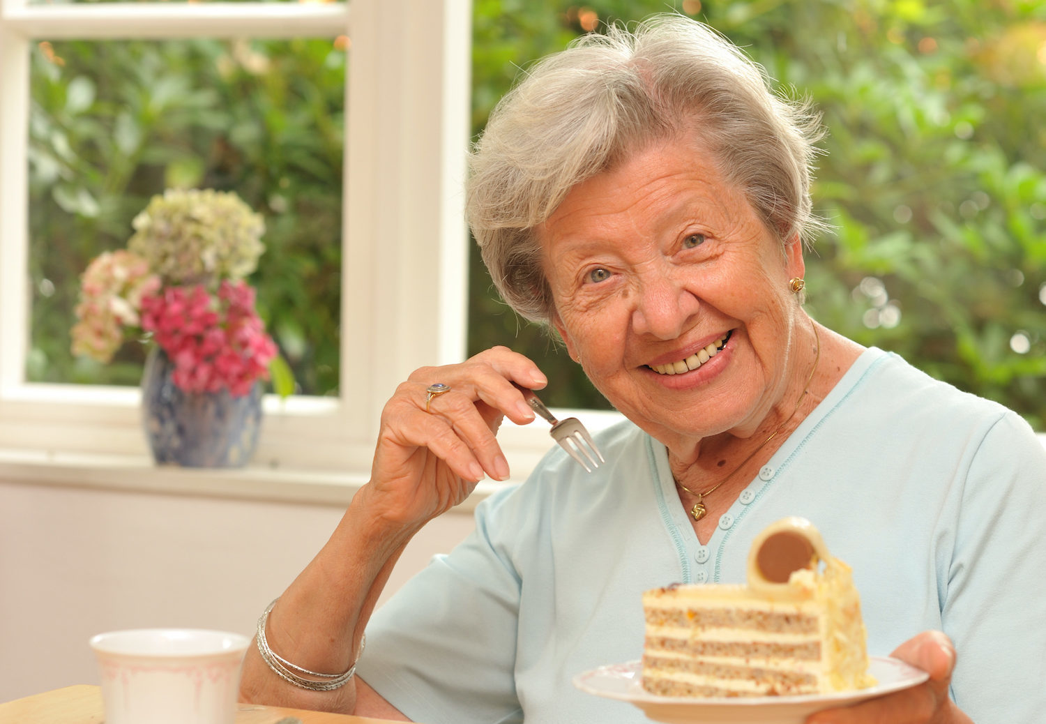 Senior woman enjoying cake with a smile