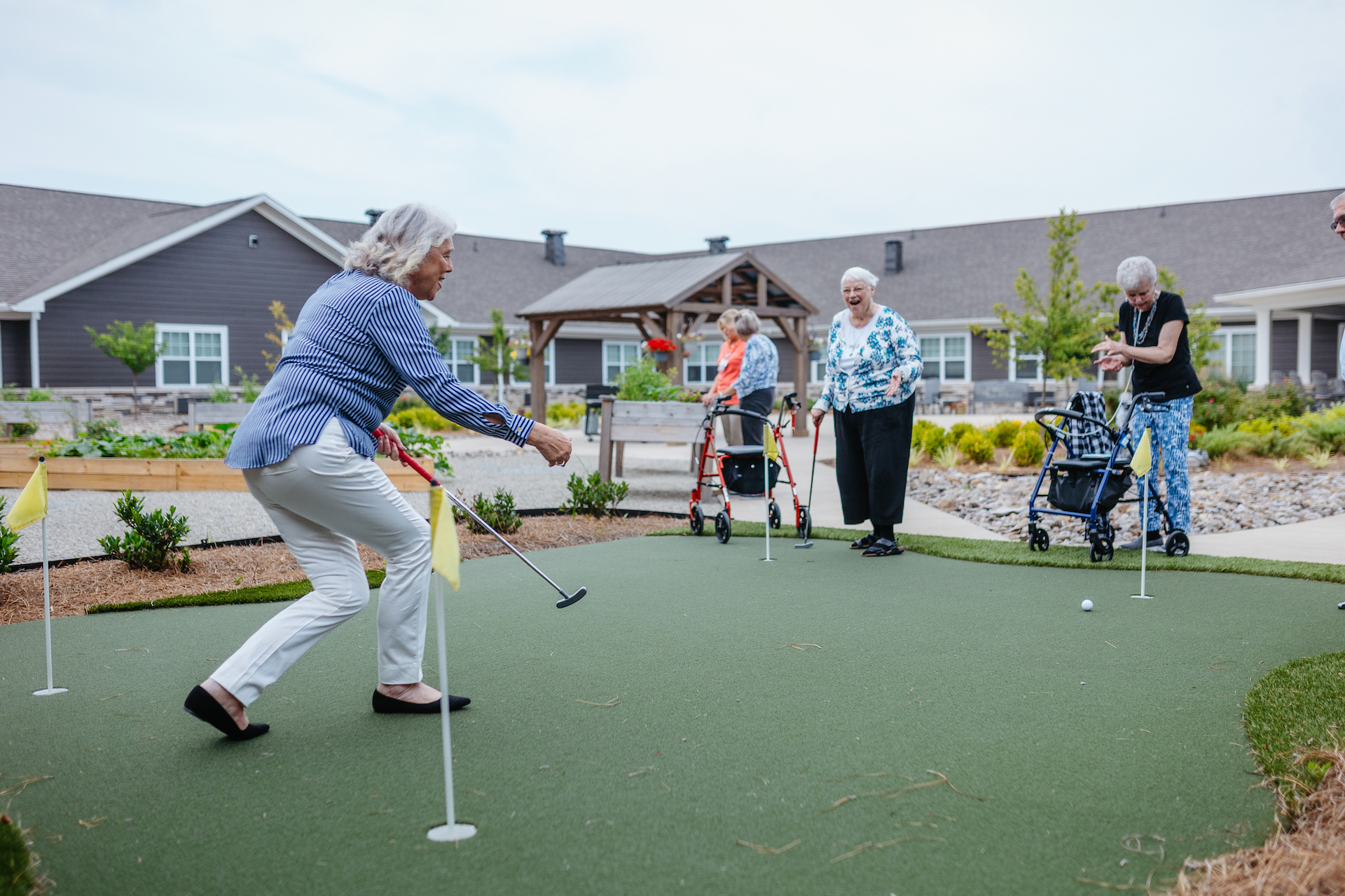 Residents enjoying a putting green activity outside.