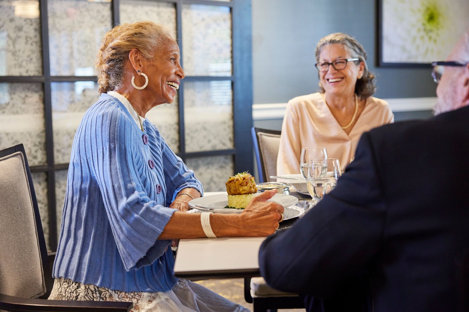 Residents enjoying a meal and sharing laughter.
