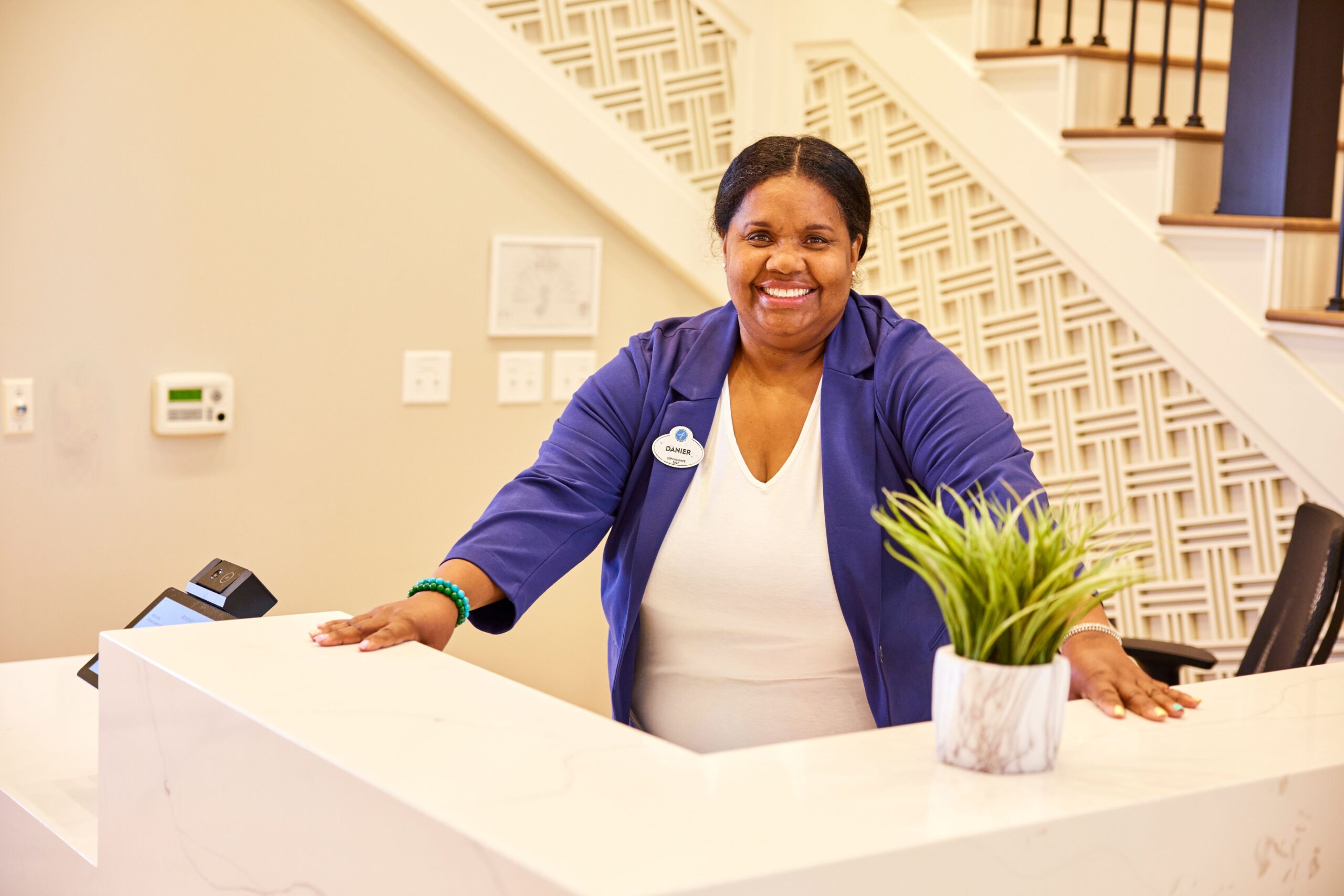 Receptionist smiling at the front desk in a facility