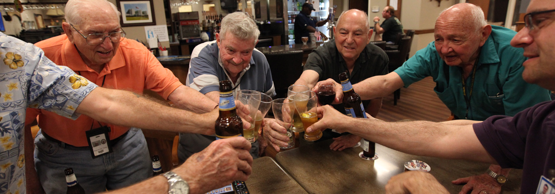 Residents cheer with drinks in a communal setting.