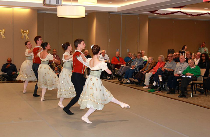 Residents watching a dance performance in a common area.