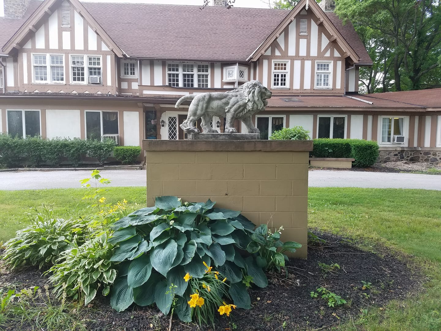 Exterior view of Broadfield Care Center with a lion statue