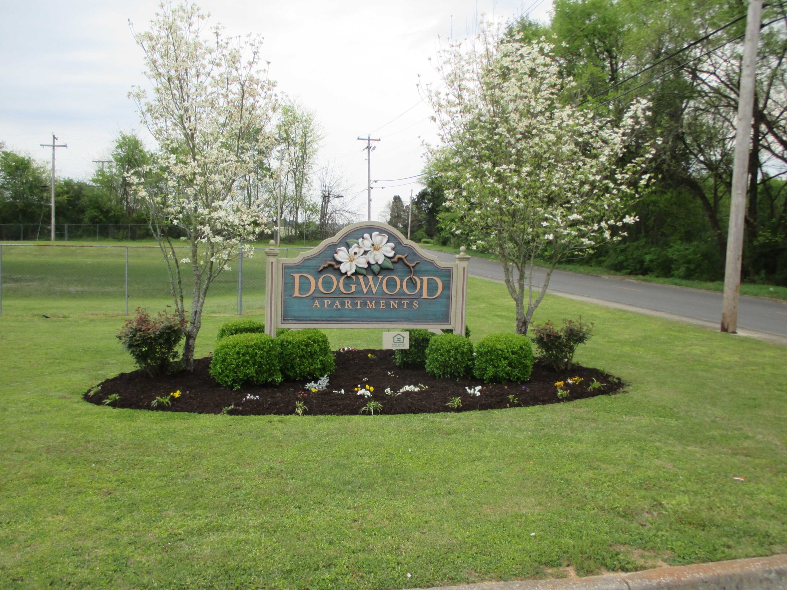 Sign for Dogwood Apartments surrounded by flowers