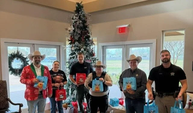 Residents and staff celebrating with gifts in a festive lobby