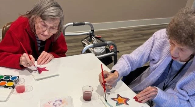 Residents painting colorful stars at a table