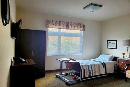 Well-furnished resident room with a bed and television