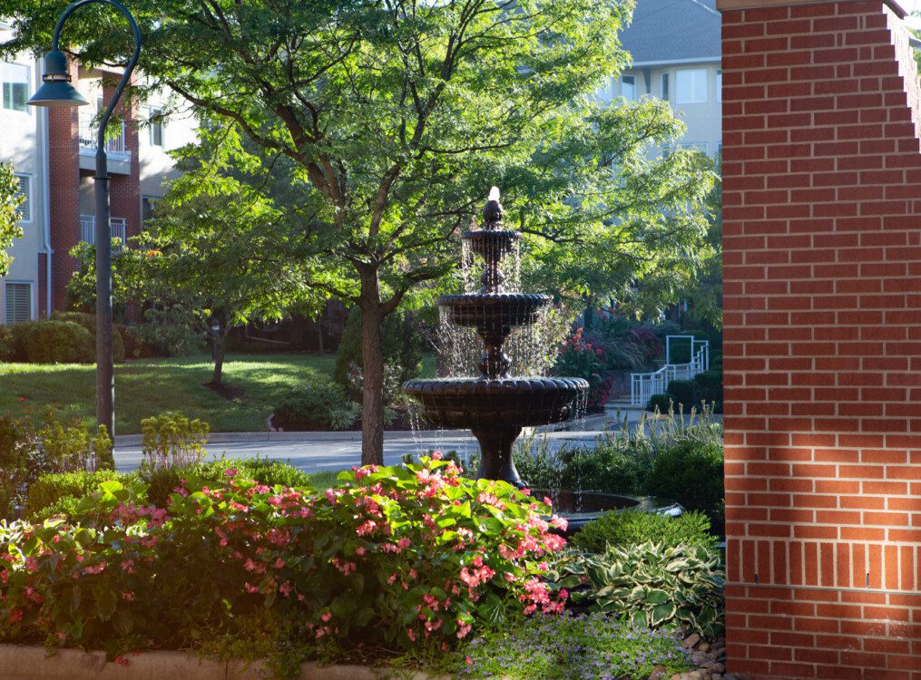A fountain surrounded by colorful flowers in an outdoor area