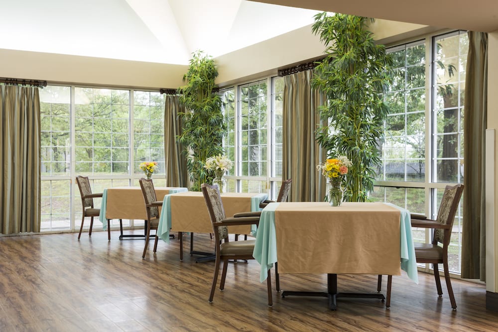 Bright dining area with large windows and floral arrangements