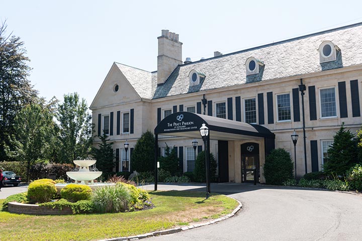Front entrance of a senior living facility with a garden