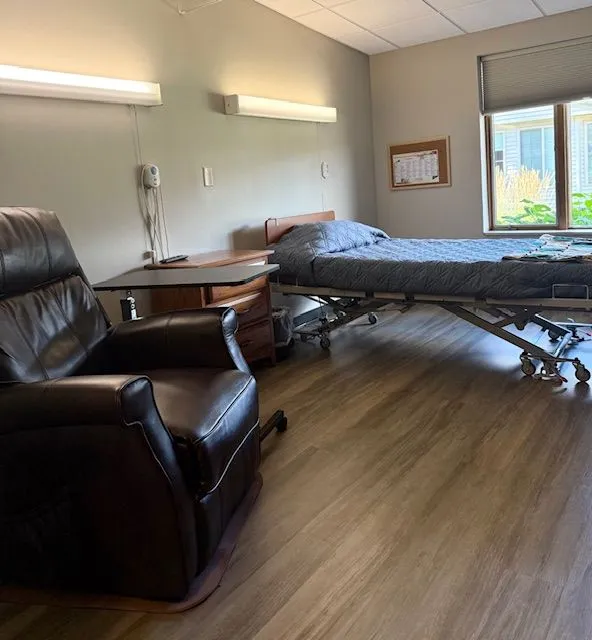 A private resident room with a bed and seating area