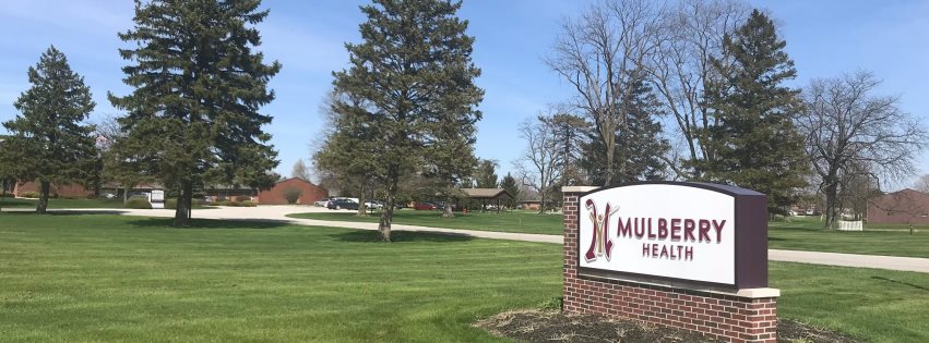 Exterior view of Mulberry Health facility sign with landscaping