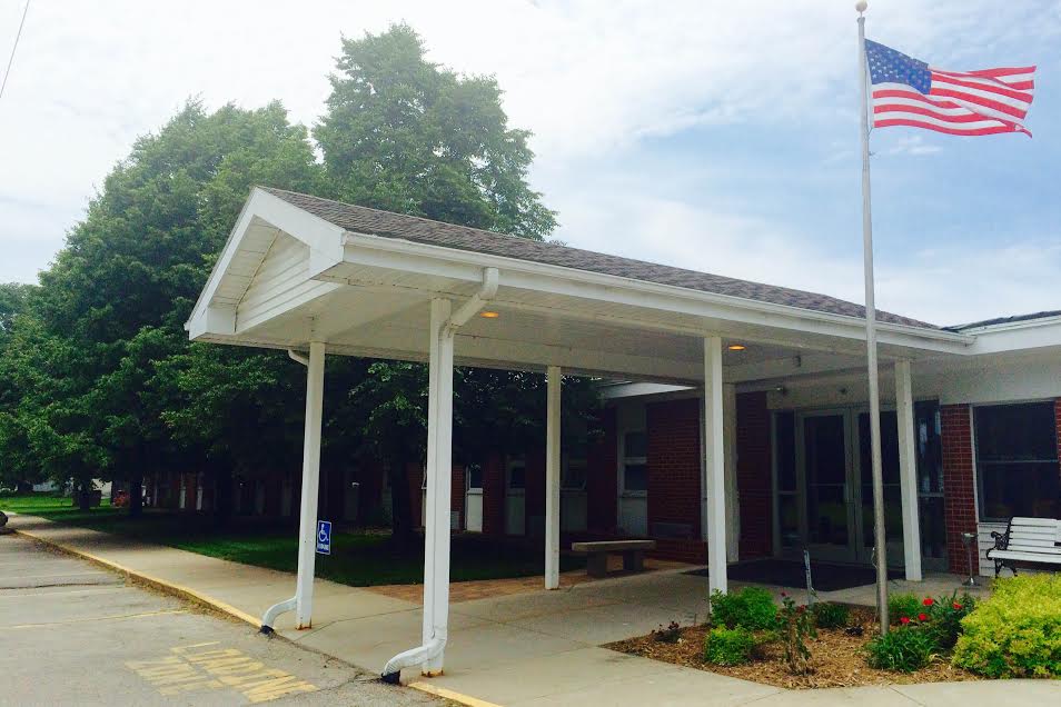 Front entrance of a nursing home with an American flag