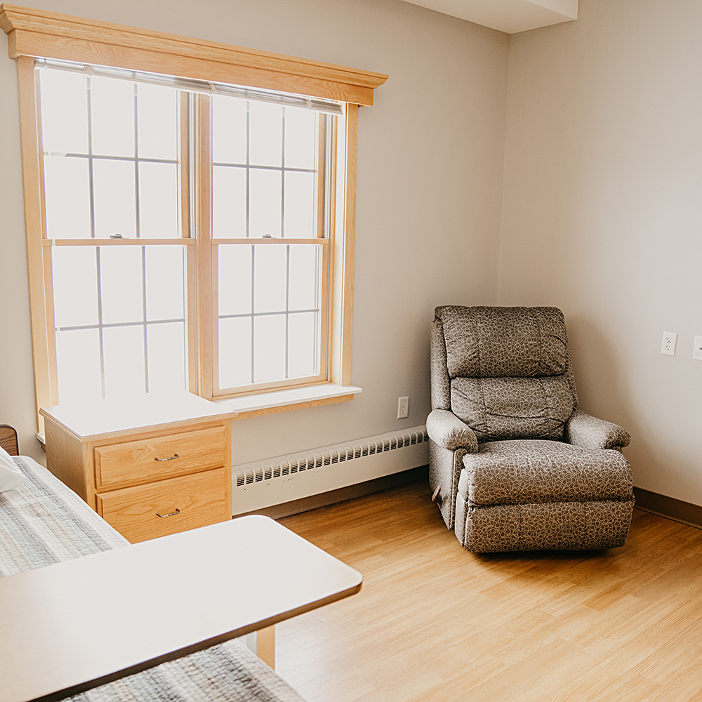 Cozy resident room with window and recliner chair