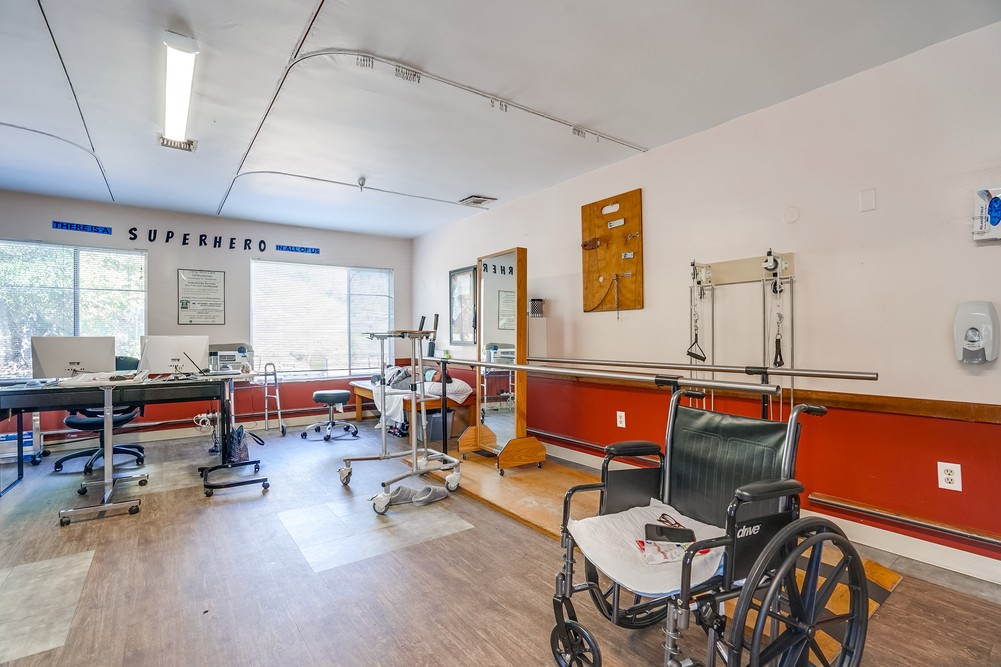 Rehabilitation room with exercise equipment and a wheelchair