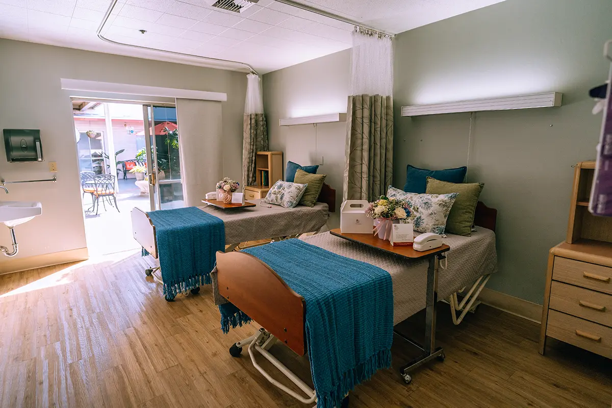 A well-lit shared room with two beds and decor