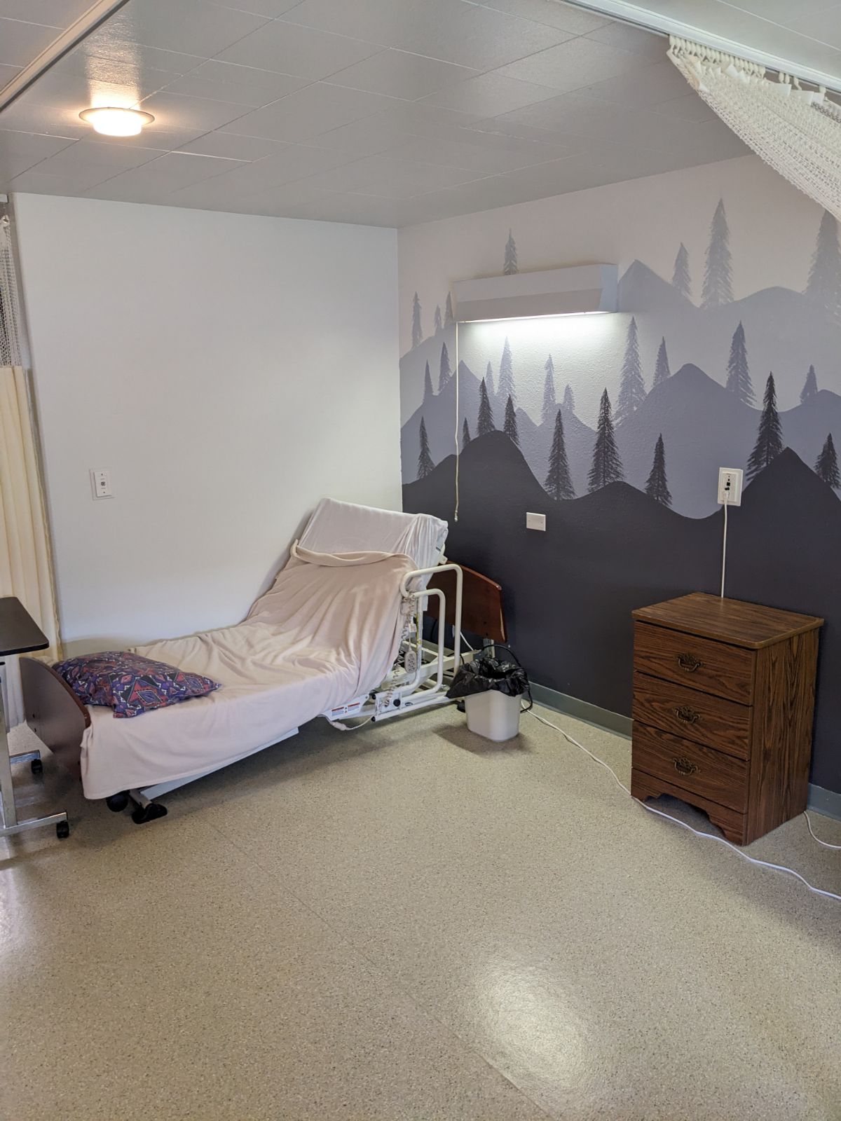 Interior view of a resident room with a bed and dresser