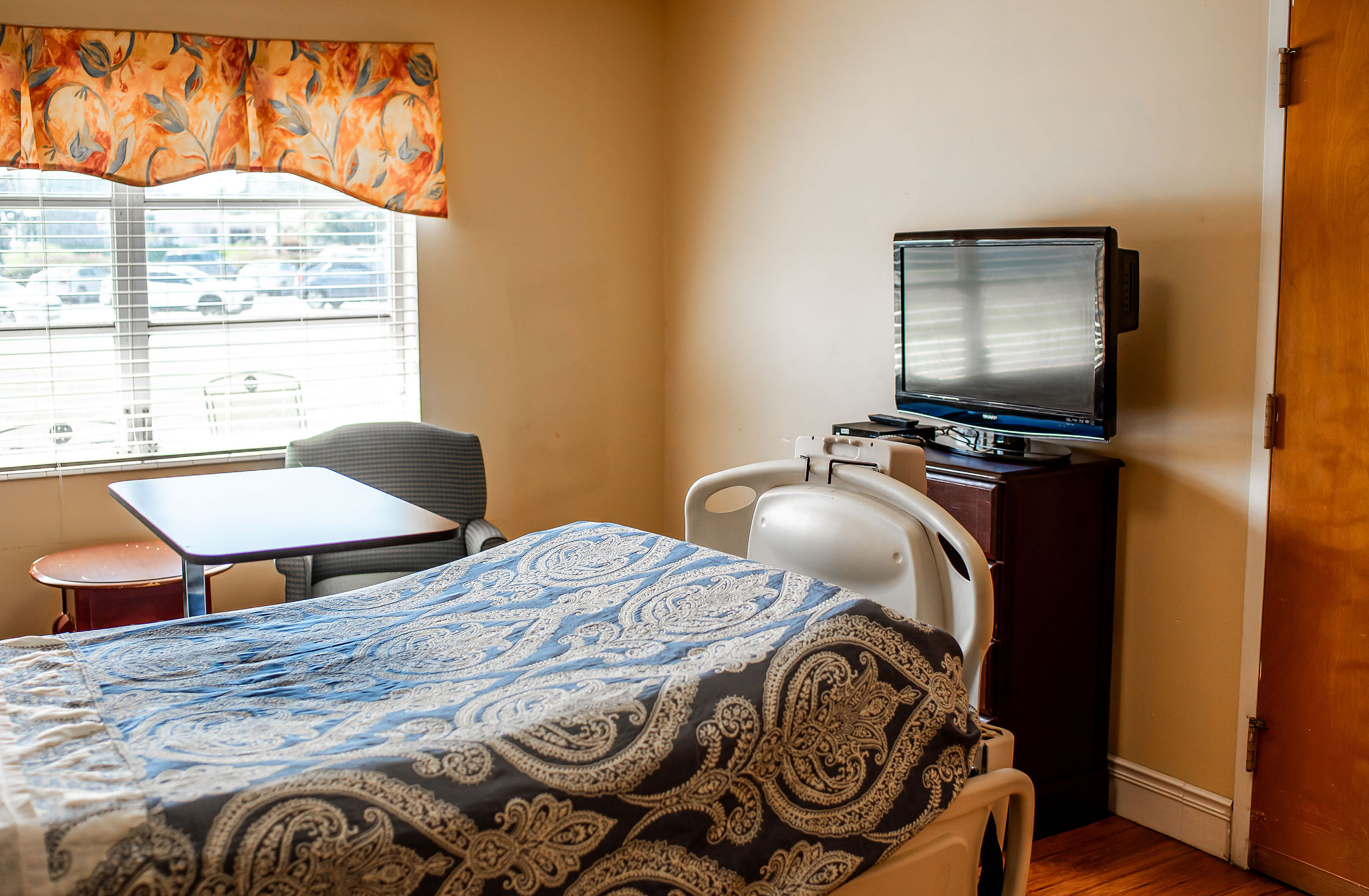 A cozy resident room with a bed and TV