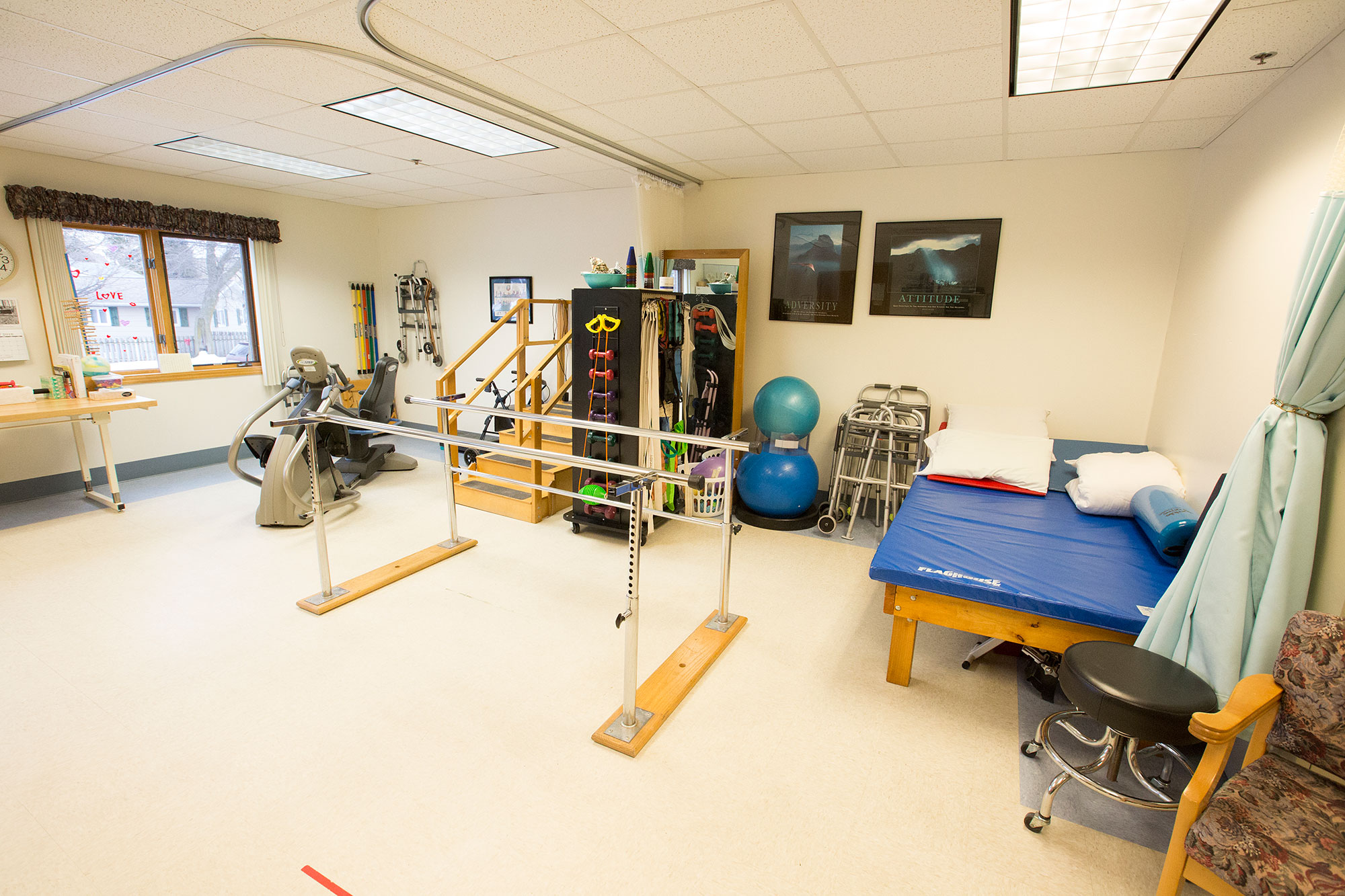 Physical therapy room with exercise equipment and mats