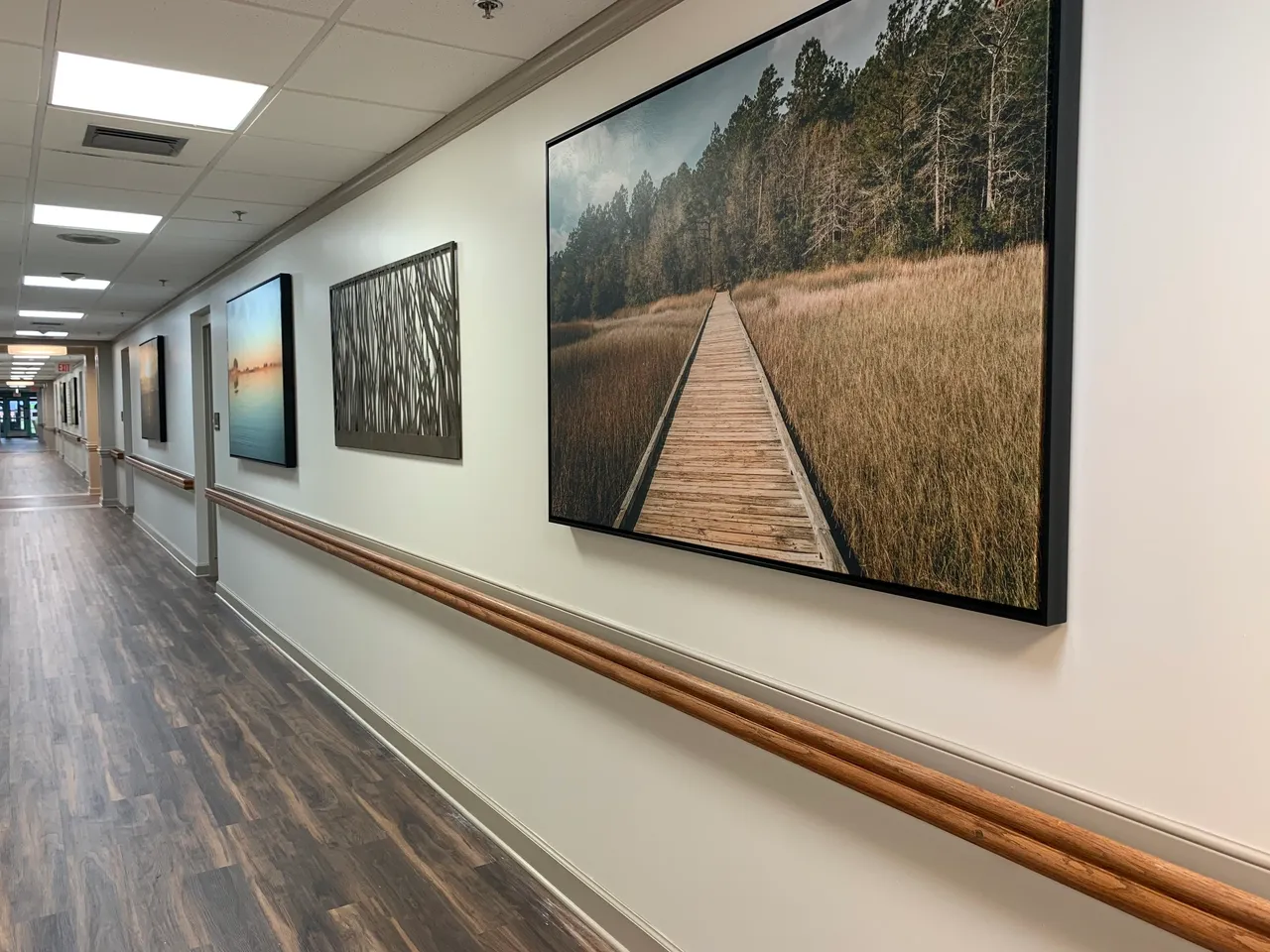 A corridor with framed landscape photos on the walls
