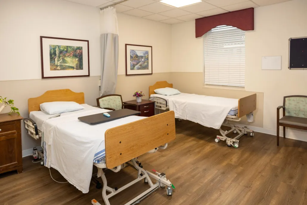 A shared resident room with two beds and artwork