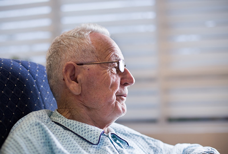 Senior man sitting thoughtfully in a chair.