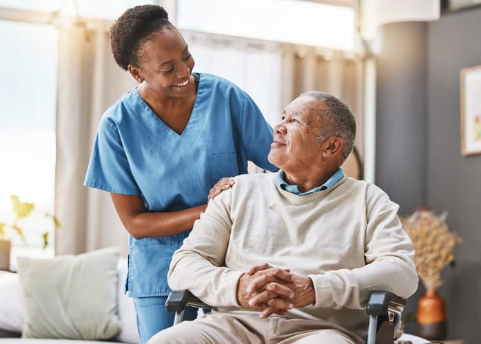 Caregiver and resident sharing a joyful moment indoors.