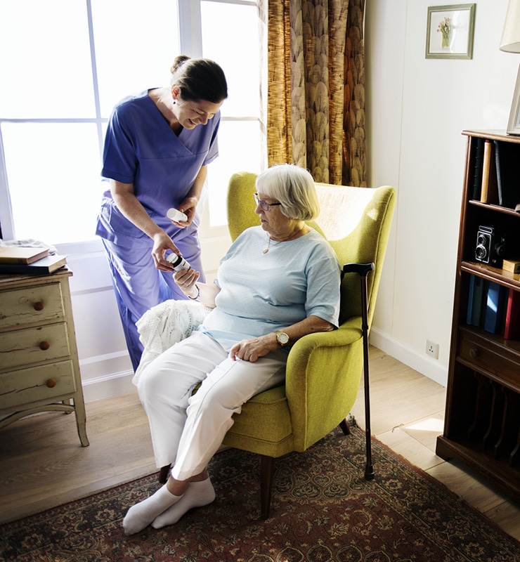 Nurse assisting a resident in a cozy chair